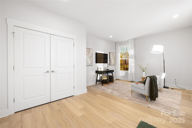 living area featuring baseboards, recessed lighting, and wood finished floors