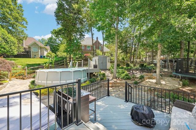 8056 Stevens Mill Rd, Matthews, NC 28104 - deck with a shed, an outdoor pool, a trampoline, a fenced backyard, and a grill