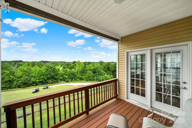 wooden deck featuring a lawn