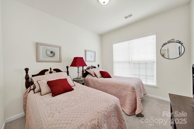 bedroom with baseboards, visible vents, and carpet