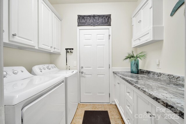laundry area with cabinet space, separate washer and dryer, and light tile patterned flooring
