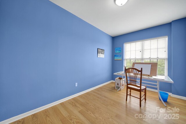 home office with baseboards and wood finished floors