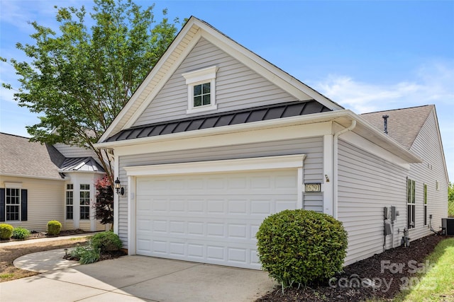 16291 Raven Crest Dr, Indian Land, SC 29707 - view of side of home featuring central AC, a garage, a standing seam roof, driveway, and metal roof