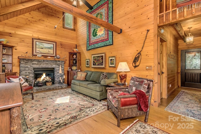 41 Log Cabin Dr, Maggie Valley, NC 28751 - living area with a ceiling fan, a fireplace, wood finished floors, beamed ceiling, and wooden walls