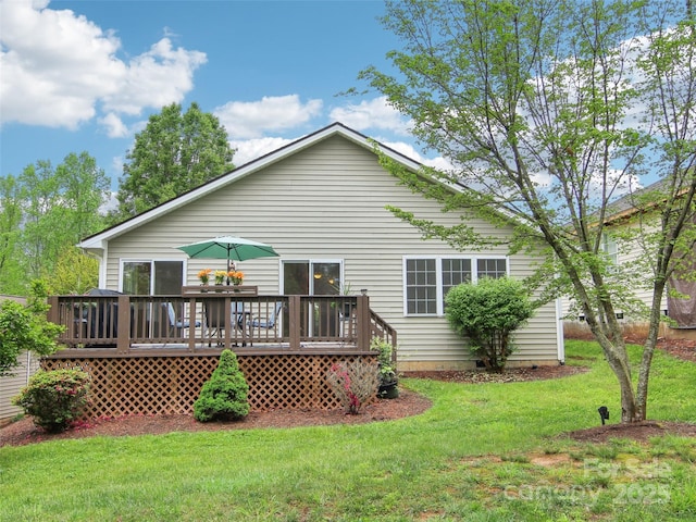 rear view of house featuring a yard and a deck