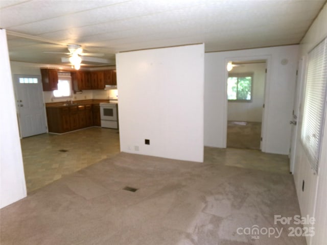 44716 Gold Branch Rd, Richfield, NC 28137 - unfurnished living room featuring a healthy amount of sunlight, light carpet, and a ceiling fan