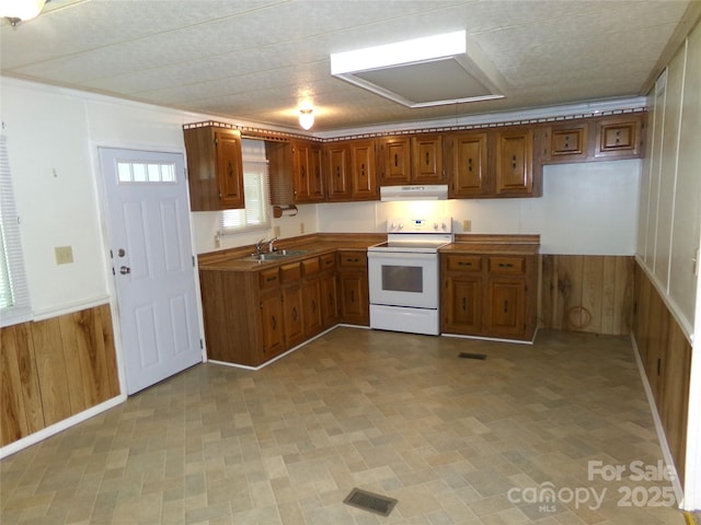 44716 Gold Branch Rd, Richfield, NC 28137 - kitchen featuring brown cabinetry, wainscoting, white range with electric cooktop, wooden walls, and exhaust hood