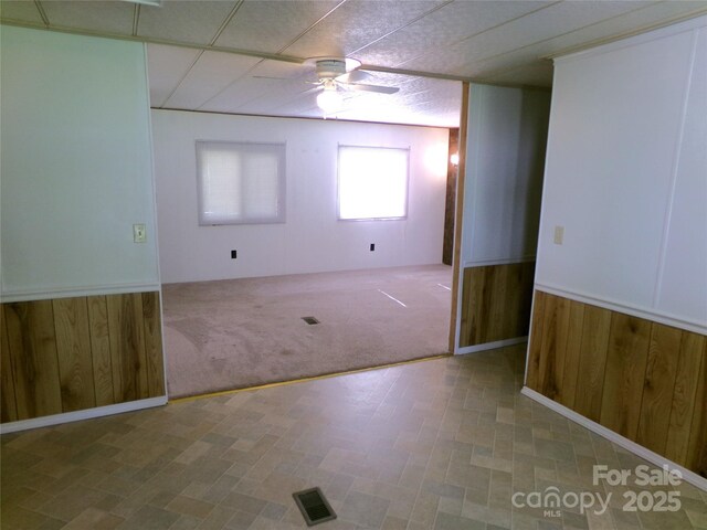44716 Gold Branch Rd, Richfield, NC 28137 - empty room with a wainscoted wall, tile patterned floors, a ceiling fan, and wood walls