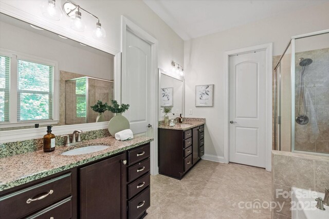 full bathroom with tile patterned flooring, a sink, and a stall shower