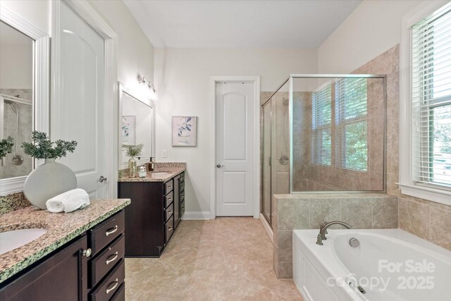 bathroom featuring two vanities, a sink, a garden tub, and a stall shower