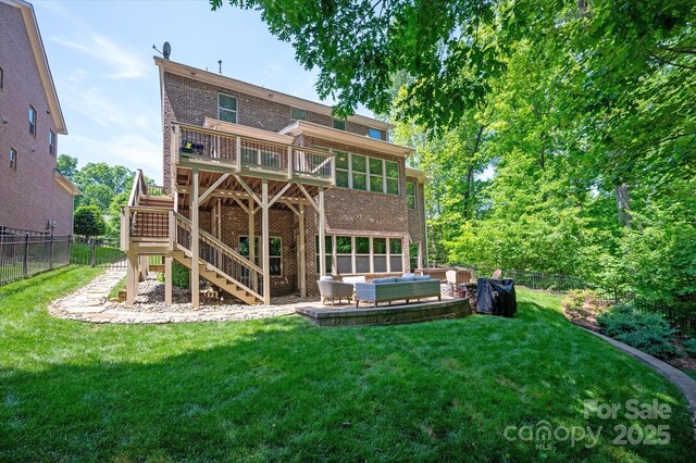 back of property with an outdoor living space, a fenced backyard, a yard, and brick siding