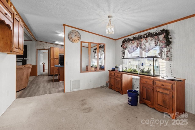 interior space featuring crown molding, an inviting chandelier, light carpet, a textured ceiling, and visible vents