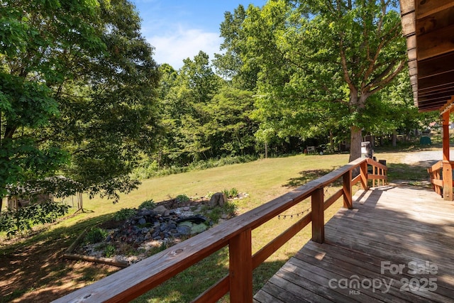 wooden terrace featuring a yard