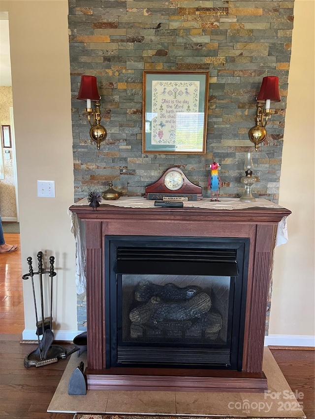 interior details featuring baseboards, wood finished floors, and a fireplace