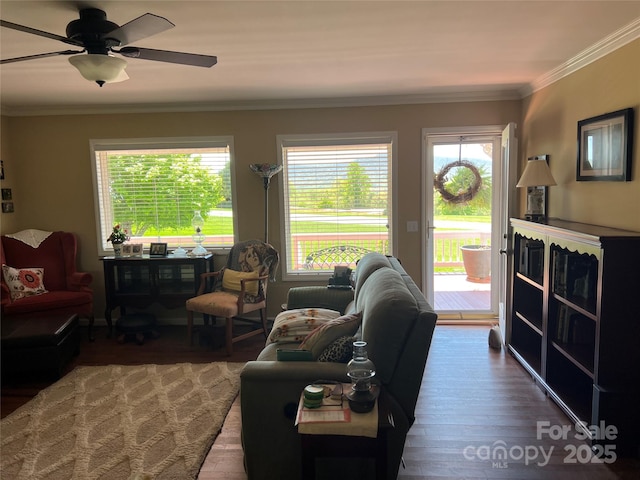 living area with ornamental molding, ceiling fan, and wood finished floors