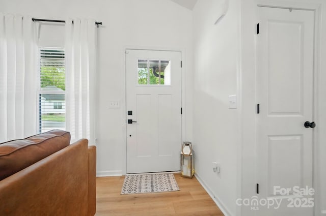 entrance foyer with baseboards and light wood-style floors