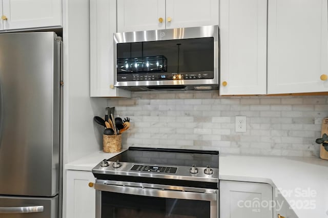 kitchen with light countertops, decorative backsplash, stainless steel appliances, and white cabinets
