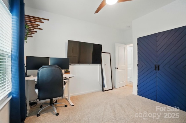 home office featuring ceiling fan and light carpet