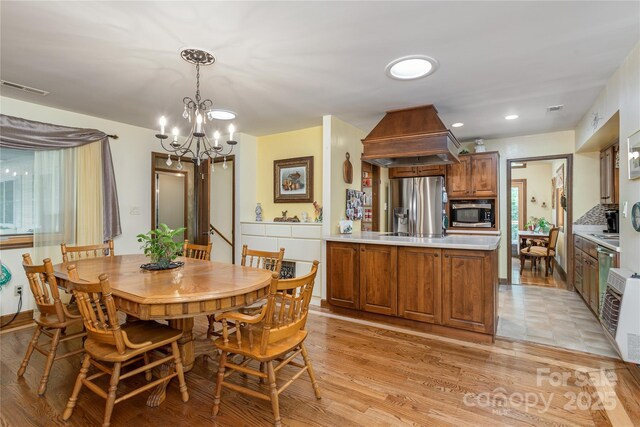 dining room with a chandelier, light wood-style flooring, and recessed lighting