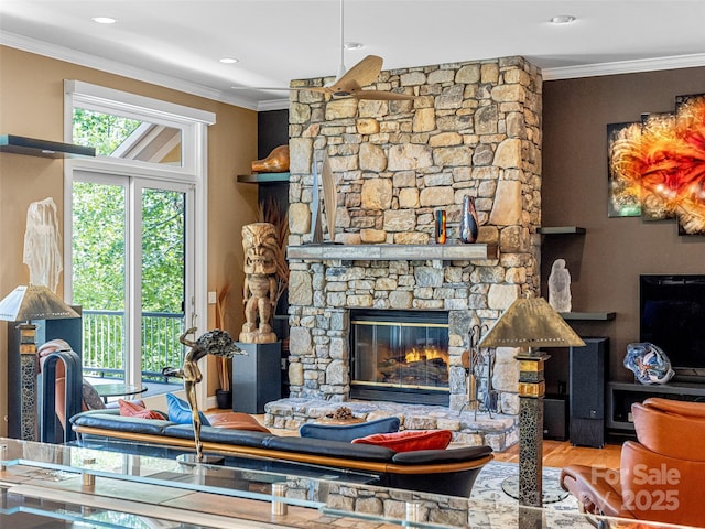 living room featuring crown molding, recessed lighting, wood finished floors, and a stone fireplace