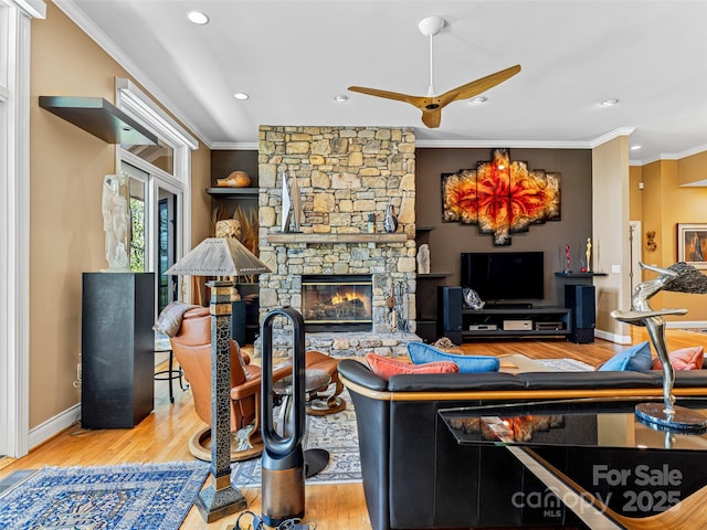 living room with ornamental molding, wood finished floors, a fireplace, ceiling fan, and recessed lighting