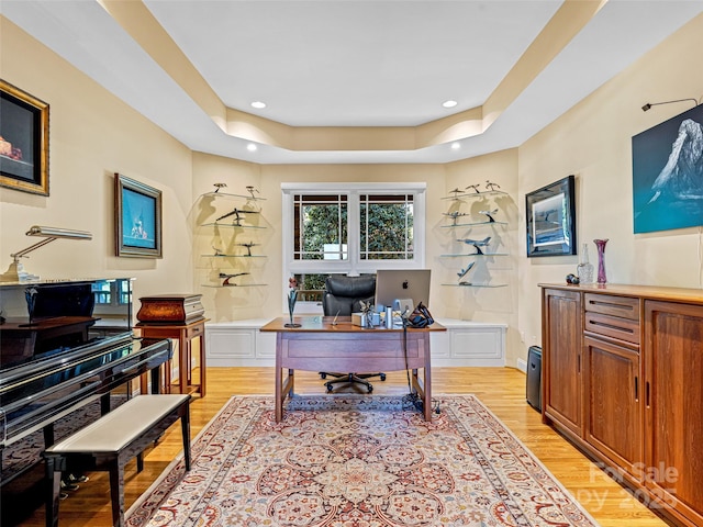 home office featuring recessed lighting, a tray ceiling, and light wood-type flooring