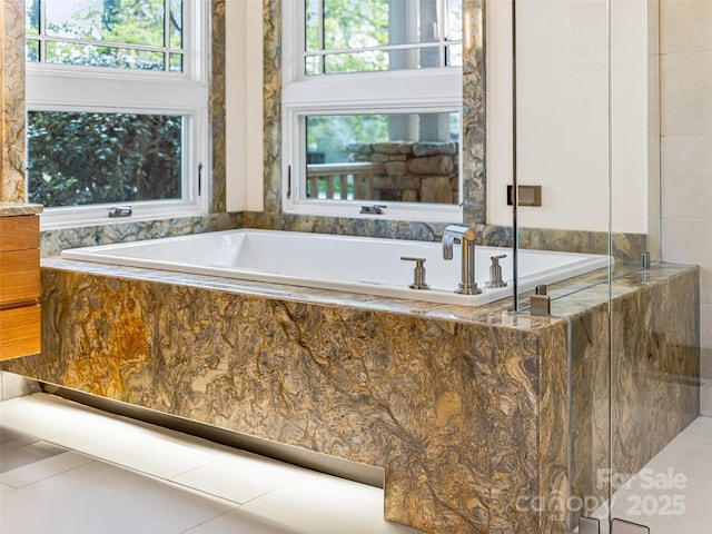 bathroom with tile patterned flooring and a bath