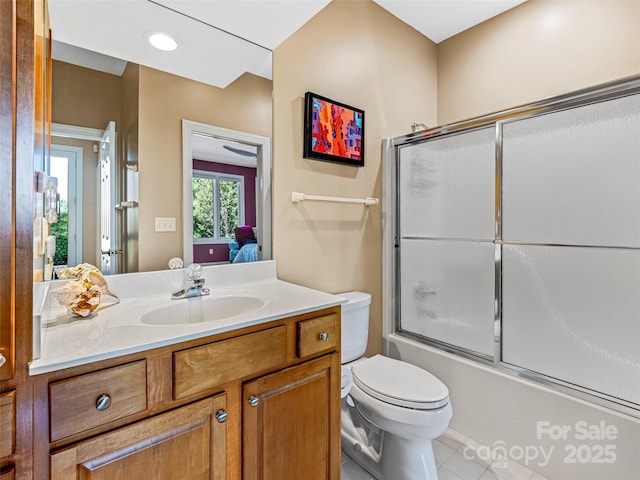 ensuite bathroom featuring tile patterned flooring, vanity, combined bath / shower with glass door, toilet, and connected bathroom