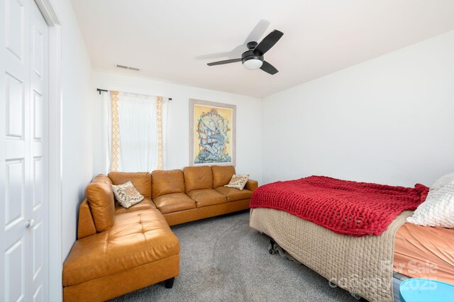 carpeted bedroom featuring visible vents, ceiling fan, and a closet