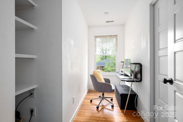 office area with visible vents, baseboards, and wood finished floors