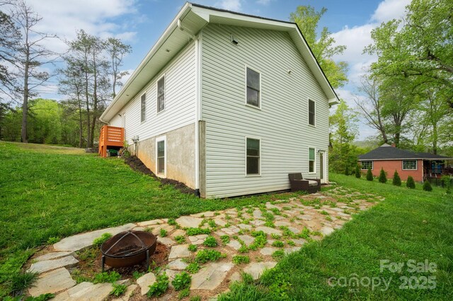 rear view of house with a yard and a fire pit