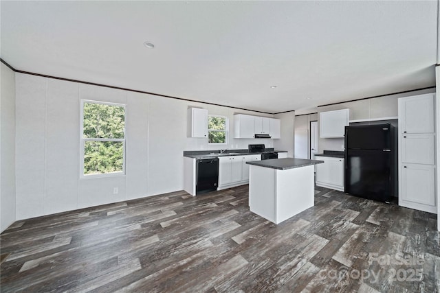 kitchen with white cabinets, dark wood-style flooring, dark countertops, a sink, and black appliances