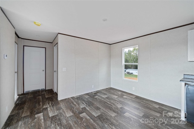 unfurnished room with ornamental molding and wood finished floors