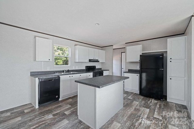 kitchen featuring dark countertops, white cabinetry, under cabinet range hood, dark wood-style floors, and black appliances