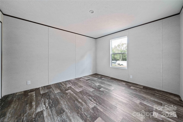 unfurnished room featuring a textured ceiling and wood finished floors