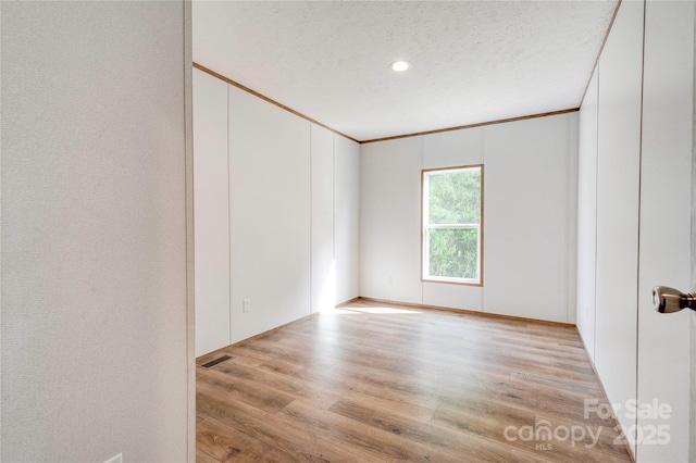 445 Davis Rd, Shelby, NC 28152 - empty room featuring wood finished floors, crown molding, a textured ceiling, visible vents, and recessed lighting