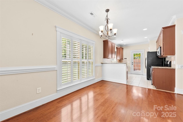 kitchen with a notable chandelier, visible vents, ornamental molding, and light wood-style floors