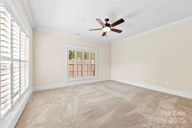 carpeted empty room with baseboards, ornamental molding, ceiling fan, and visible vents