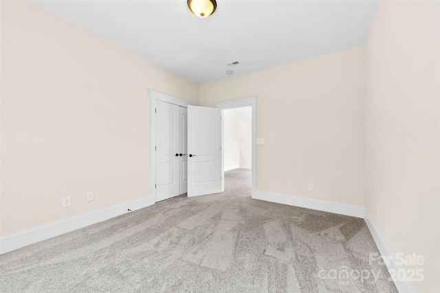 spare room featuring carpet floors, baseboards, and visible vents