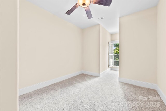 spare room featuring carpet floors, ceiling fan, visible vents, and baseboards