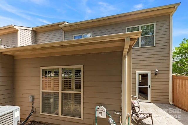 back of house with fence, central AC unit, and a patio area