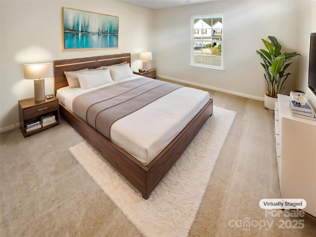 bedroom with baseboards and light carpet