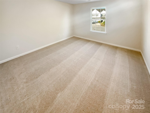 carpeted spare room with baseboards