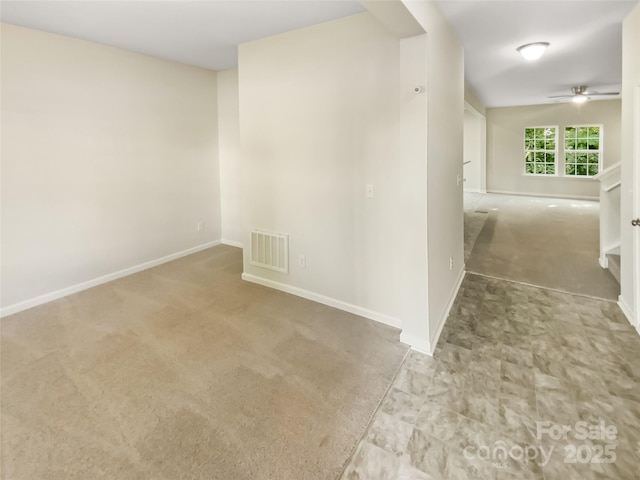 carpeted empty room featuring a ceiling fan, baseboards, and visible vents