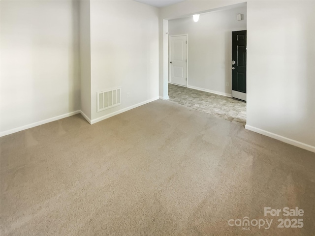 carpeted empty room with visible vents and baseboards