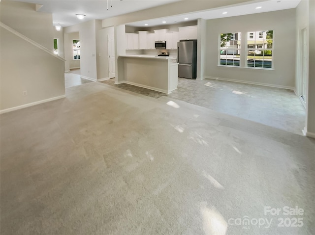 unfurnished living room featuring baseboards, recessed lighting, and light carpet