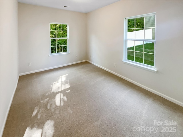 spare room with baseboards and carpet flooring
