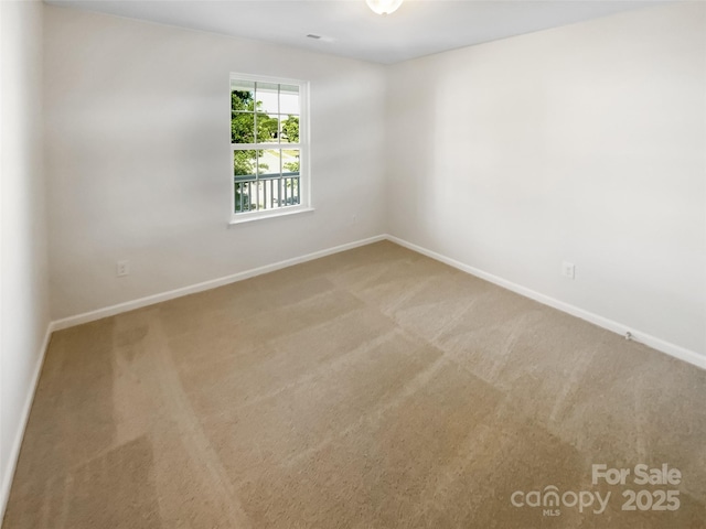 unfurnished room featuring baseboards and carpet
