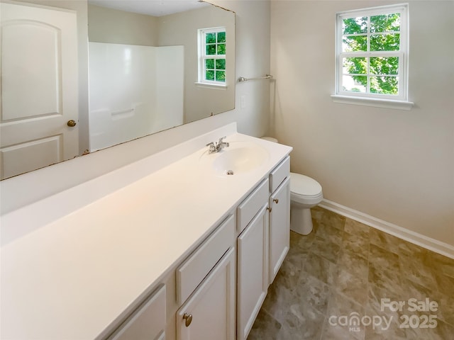 bathroom featuring vanity, baseboards, and toilet