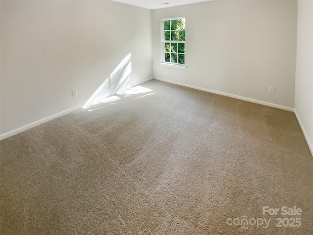 unfurnished room with baseboards and carpet